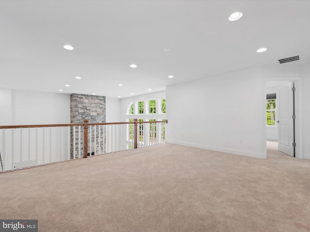 spare room featuring light colored carpet and a healthy amount of sunlight