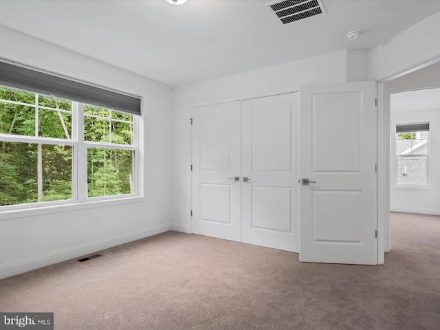 unfurnished bedroom featuring carpet flooring and a closet