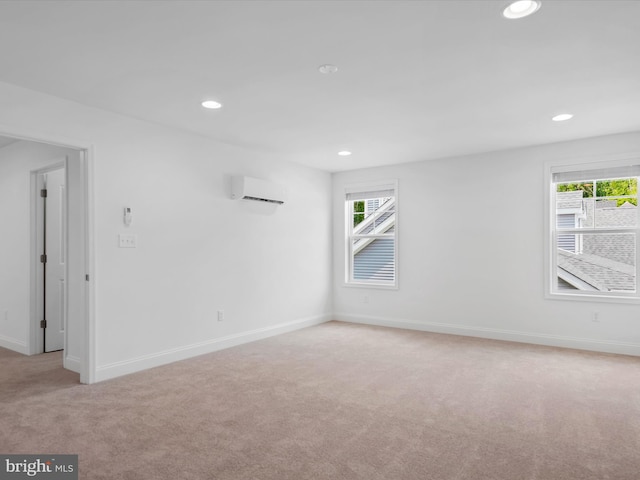 unfurnished room with light colored carpet and a wall mounted AC