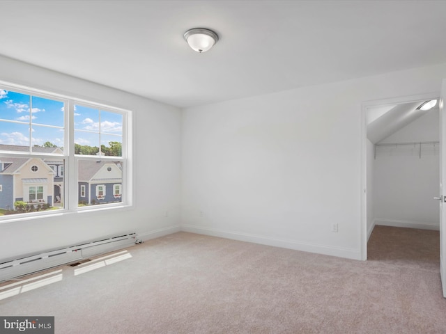 carpeted empty room with a baseboard heating unit