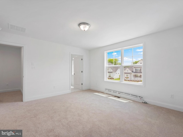 spare room with baseboard heating and light carpet