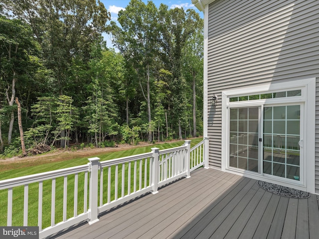 wooden terrace featuring a lawn