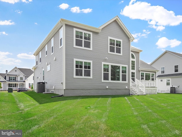 back of house with a yard and central AC unit