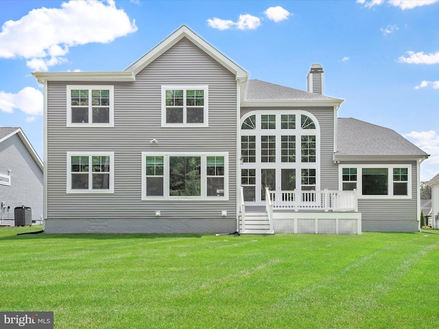 rear view of house featuring cooling unit, a yard, and a deck