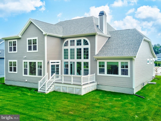 rear view of house featuring a yard and a deck