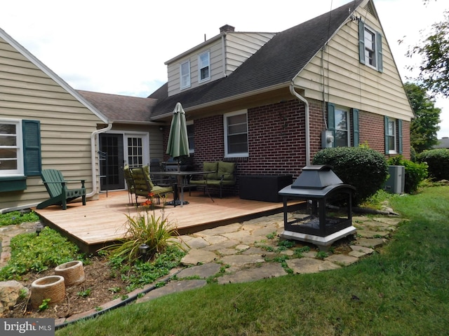 rear view of house with a deck and a yard