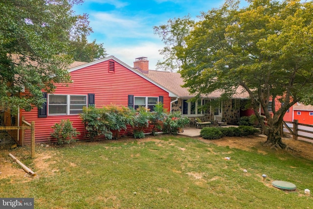 back of house featuring a patio and a yard