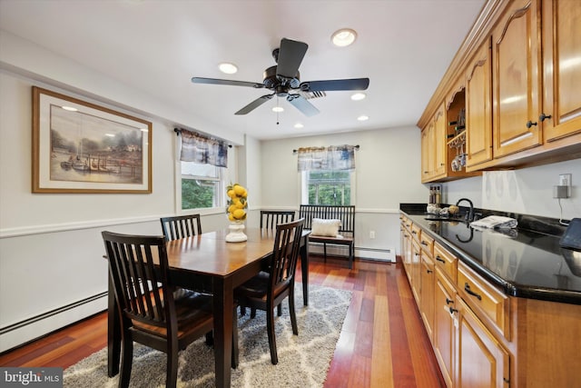 dining area featuring baseboard heating, dark hardwood / wood-style floors, ceiling fan, and sink