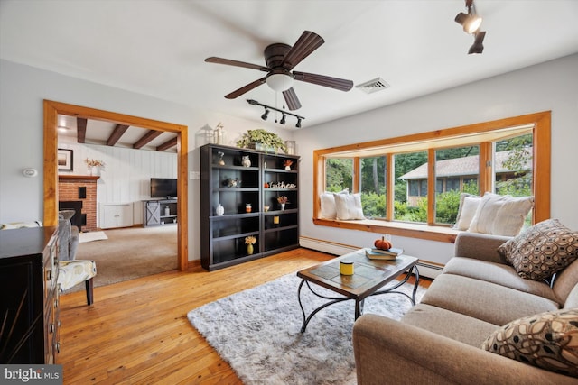 living room featuring ceiling fan, a brick fireplace, wood-type flooring, and a wealth of natural light