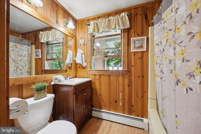 bathroom with a shower with curtain, baseboard heating, vanity, and toilet