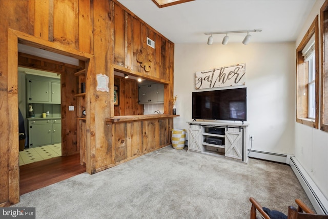 carpeted living room featuring a baseboard heating unit and track lighting