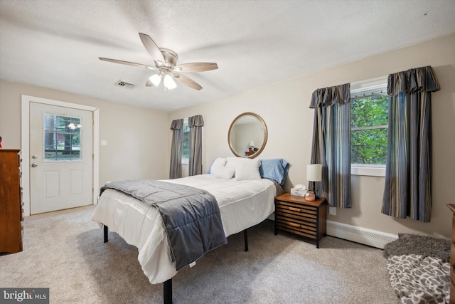 bedroom featuring a baseboard radiator, ceiling fan, light colored carpet, and a textured ceiling