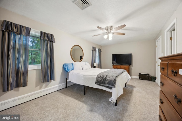 carpeted bedroom featuring baseboard heating and ceiling fan