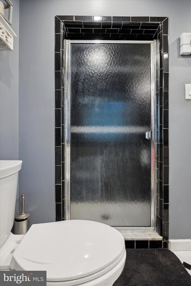 bathroom with walk in shower, tile patterned flooring, and toilet