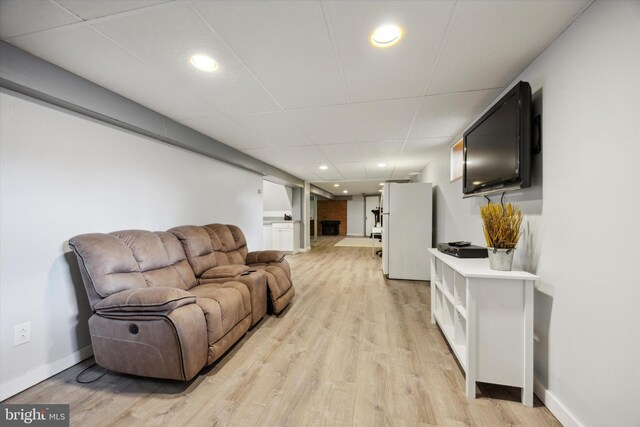 living room with a drop ceiling and light hardwood / wood-style flooring