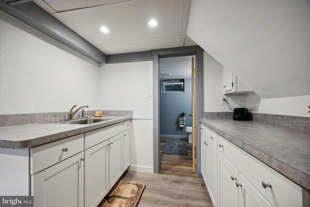 kitchen with light hardwood / wood-style floors, sink, and white cabinets