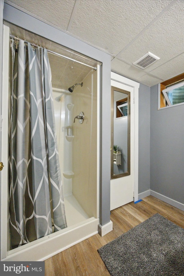 bathroom with hardwood / wood-style flooring and a shower with shower curtain