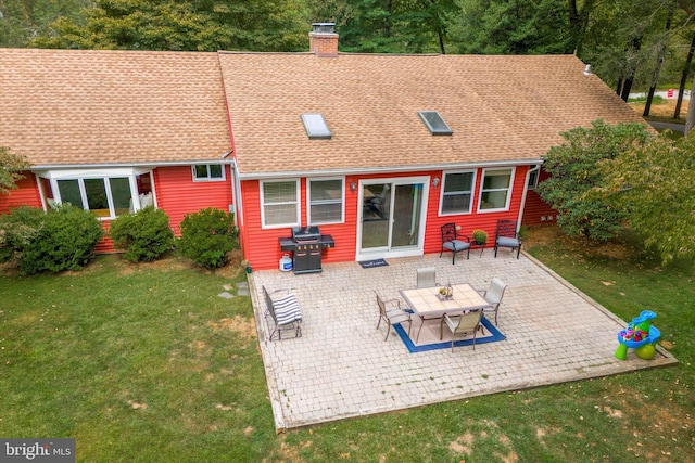 rear view of property with a patio and a yard