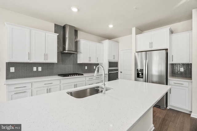 kitchen featuring stainless steel appliances, sink, white cabinets, and wall chimney exhaust hood