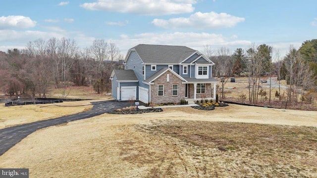 view of property featuring a garage and a front lawn