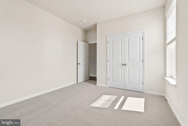 unfurnished bedroom featuring a closet and light carpet