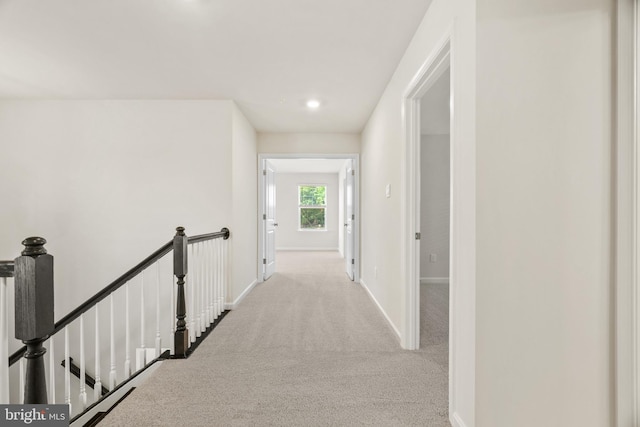 corridor featuring light colored carpet