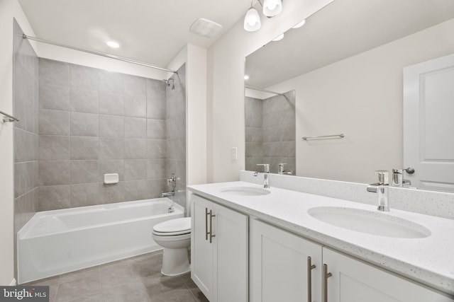 full bathroom featuring vanity, tile patterned floors, toilet, and tiled shower / bath