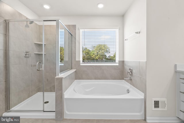 bathroom with vanity and independent shower and bath