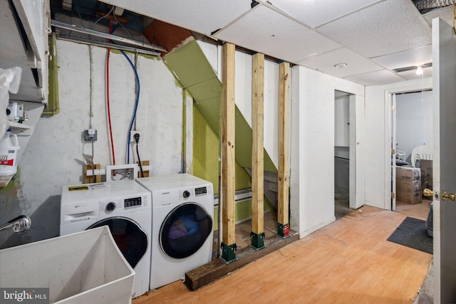 clothes washing area with washing machine and clothes dryer and sink