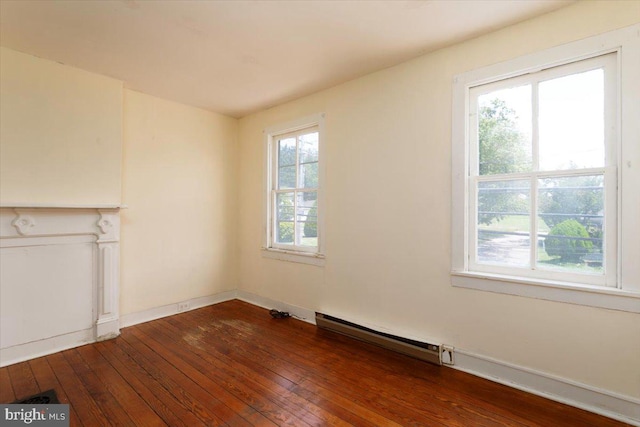 unfurnished living room featuring wood-type flooring and a baseboard heating unit