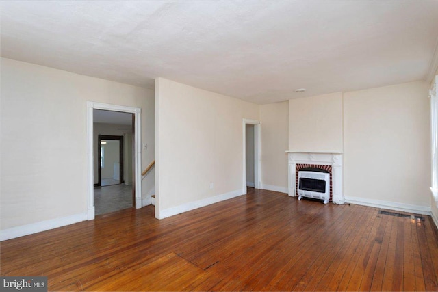 unfurnished living room with a fireplace, dark hardwood / wood-style flooring, and heating unit