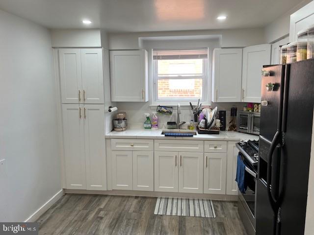 kitchen featuring white cabinetry, sink, dark hardwood / wood-style flooring, and stainless steel appliances