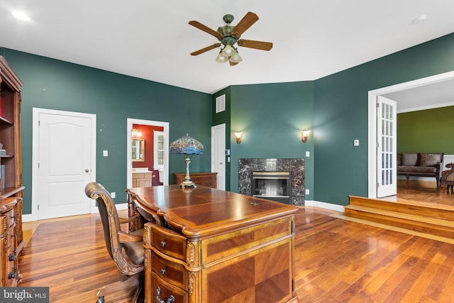 office area featuring hardwood / wood-style flooring, ceiling fan, and a fireplace