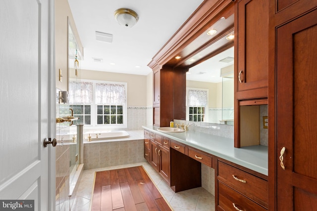 bathroom featuring vanity, tiled tub, and tile patterned floors