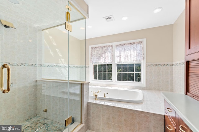 bathroom with vanity and shower with separate bathtub