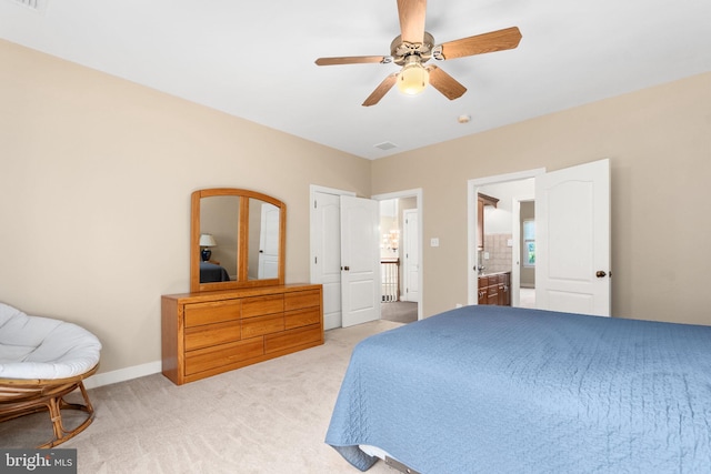 carpeted bedroom with ceiling fan and ensuite bath