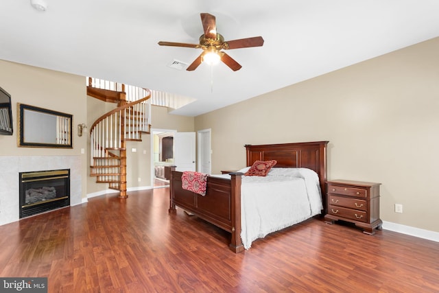 bedroom with dark hardwood / wood-style floors and a high end fireplace