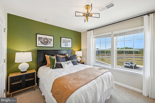 carpeted bedroom with a notable chandelier