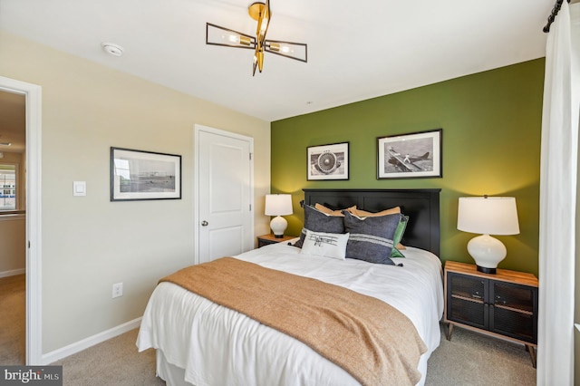 bedroom with light carpet and an inviting chandelier