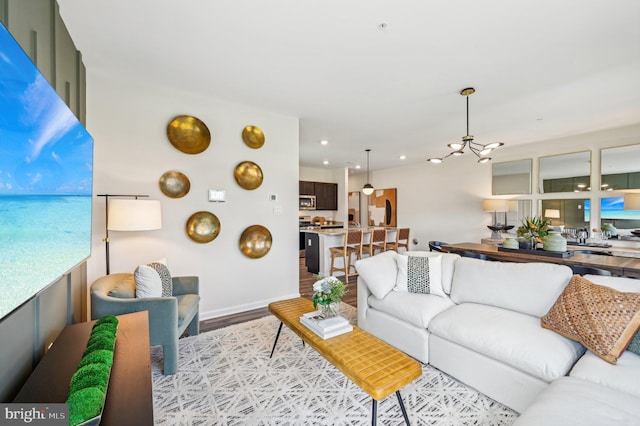 living room featuring a notable chandelier and light wood-type flooring