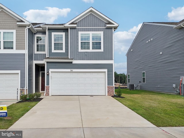 view of front of home featuring cooling unit, a garage, and a front yard