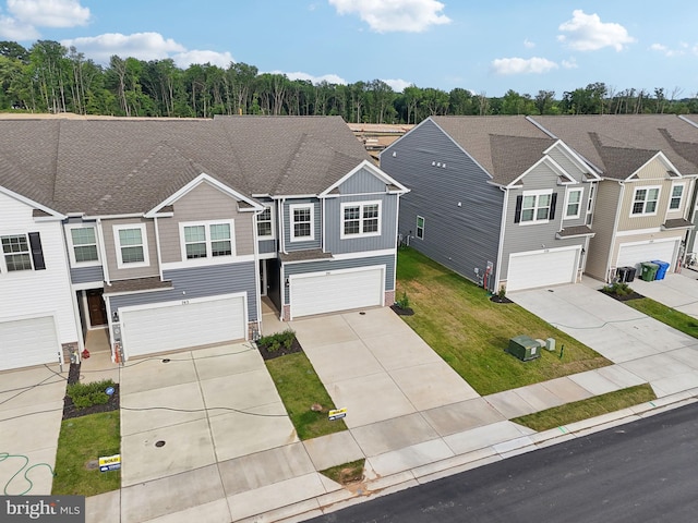 view of front of home featuring a garage, central AC, and a front yard