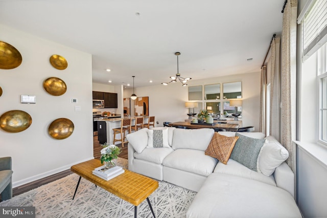 living room with an inviting chandelier and light wood-type flooring