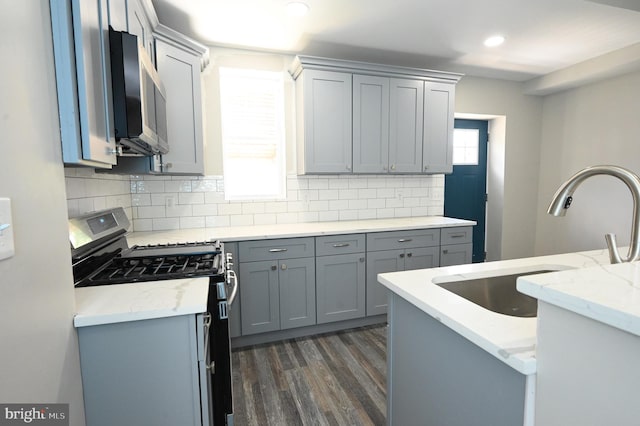 kitchen with sink, gray cabinetry, stainless steel appliances, tasteful backsplash, and light stone countertops