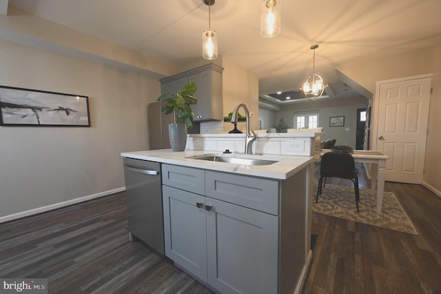 kitchen featuring gray cabinets, decorative light fixtures, dishwasher, sink, and a center island with sink