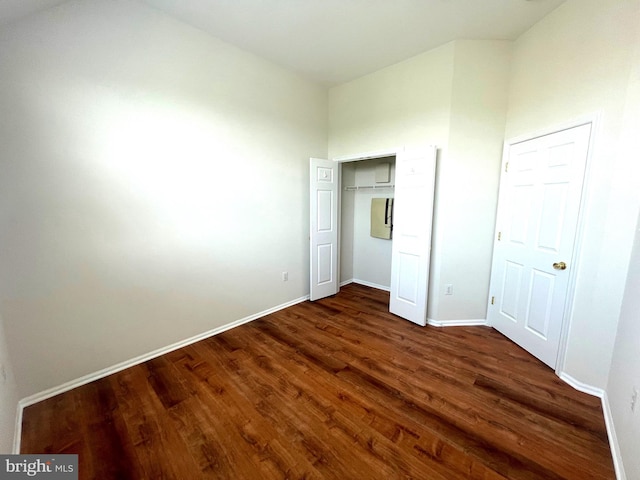 unfurnished bedroom with a closet and dark hardwood / wood-style floors