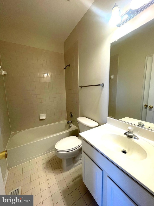 full bathroom with tiled shower / bath, vanity, tile patterned floors, and toilet