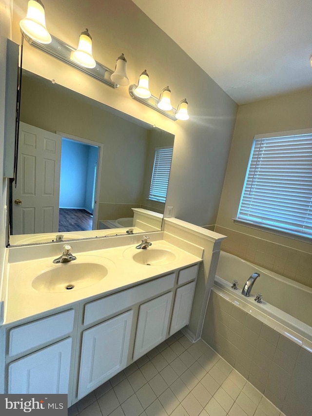 bathroom featuring vanity, tile patterned flooring, and a relaxing tiled tub