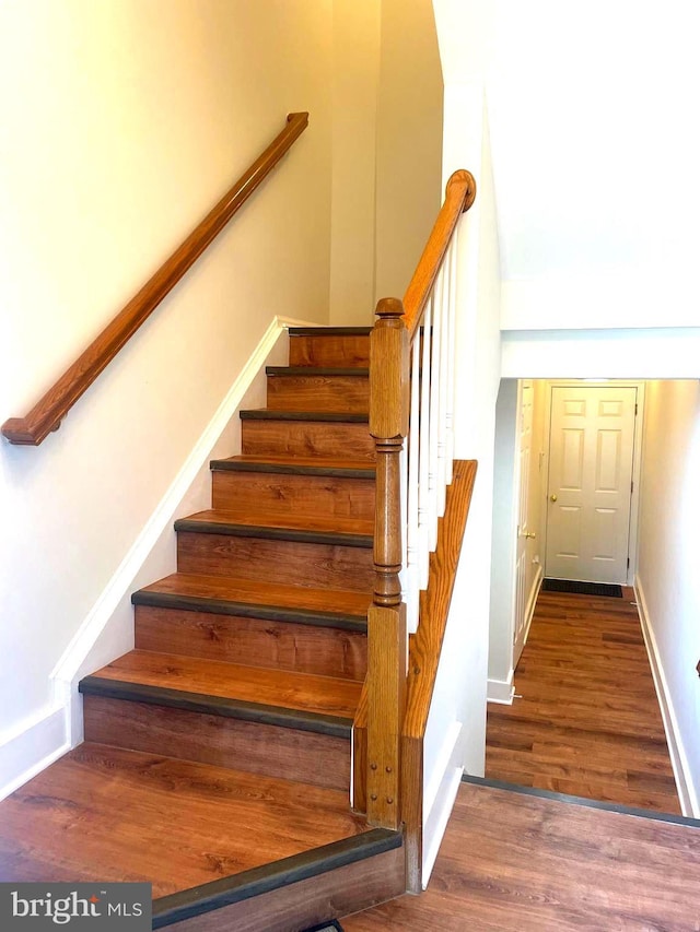 stairs with hardwood / wood-style floors