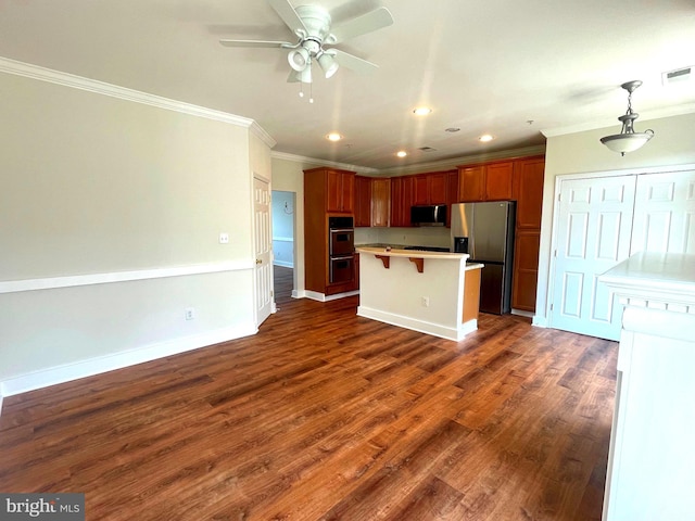 kitchen featuring appliances with stainless steel finishes, dark hardwood / wood-style floors, a kitchen bar, a center island, and crown molding